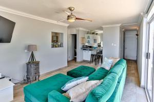 a living room with a green couch and a kitchen at Seaside 96 - Family only in Ballito
