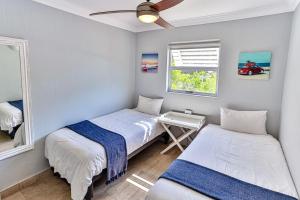 a bedroom with two beds and a window at Seaside 96 - Family only in Ballito +8 photos
