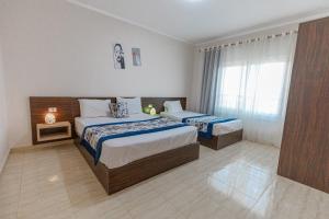 a hotel room with two beds and a window at Andalusia Blue Beach Hurghada in Hurghada +127 photos