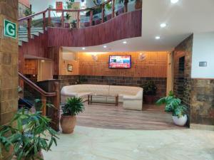 a lobby with a couch and a tv and stairs at Hotel Bali Resort in Katra