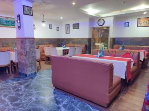 a restaurant with couches and tables and a clock on the wall at Hotel Bali Resort in Katra