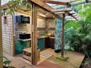 an outdoor kitchen with a pergola on a deck at Poivre et Citronnelle in Saint-André