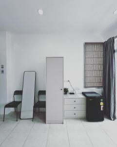 a white room with a mirror and a dresser at Shaka Guest House in Kata Beach