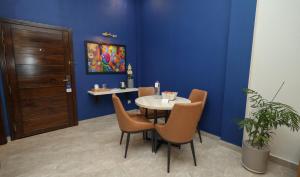 a table and chairs in a room with a blue wall at The Mark in Islamabad