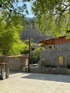 un petit bâtiment en pierre avec une montagne en arrière-plan dans l'établissement bait bimah travel lodge, à Bīmah