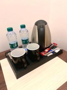 a tray with two bottles of water and two cups at داماس للأجنحة الفندقية Damas Hotel Suites in Al Maraghah