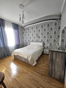 1 dormitorio con 1 cama grande y 1 mesa en Guesthouse - Family Hotel, en Bagdatʼi