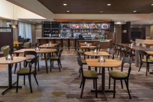 um restaurante com mesas e cadeiras e um bar em Courtyard by Marriott Jacksonville at the Mayo Clinic Campus/Beaches em Jacksonville