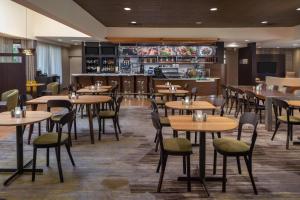 a restaurant with tables and chairs and a bar at Courtyard by Marriott Jacksonville at the Mayo Clinic Campus/Beaches in Jacksonville
