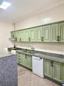 a kitchen with green cabinets and a white dishwasher at Casa Bienvenida in Bienvenida