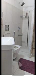 a white bathroom with a sink and a toilet at Simbha's Homestay in Jammu