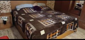 a bedroom with a large bed with a black comforter at Simbha's Homestay in Jammu
