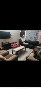 Sala de estar con sofás y mesa de centro en Simbha's Homestay, en Jammu