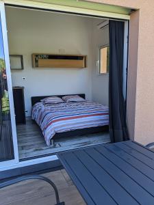 a bedroom with a bed on a balcony at Rez de jardin indépendant in Gap