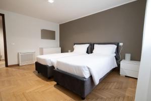1 dormitorio con 2 camas grandes con sábanas blancas en Residenza Corso Palladio 159 en Vicenza