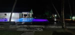 a swimming pool in front of a house at night at Thiranagama Beach Hotel in Hikkaduwa