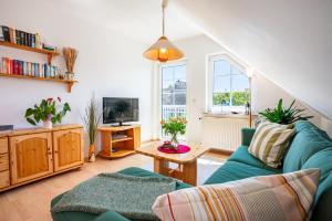 a living room with a blue couch and a tv at Pension Haus Anneliese in Ueckeritz