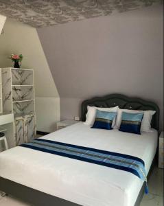 ein Schlafzimmer mit einem großen weißen Bett mit blauen Kissen in der Unterkunft วิวธารารีสอร์ท (ViewThara Resort) in Ban Chak Phak Kut