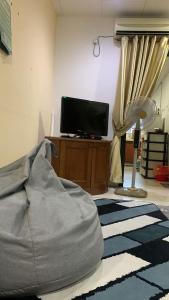 a living room with a bed and a tv at Berkat Pak Raja Homestay Mergong Alor Setar 