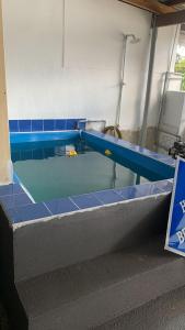 a swimming pool with blue tiles on the floor at Berkat Pak Raja Homestay Mergong Alor Setar 