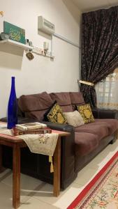 a living room with a brown couch and a table at Berkat Pak Raja Homestay Mergong Alor Setar 