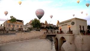 a group of hot air balloons flying over a bridge at Corner İn Cappadocia in Ortahisar