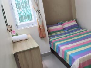 a small bedroom with a bed and a window at Lucky Home in Nha Trang