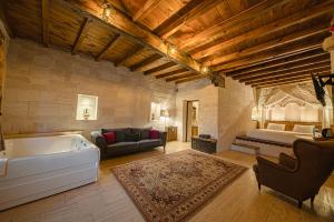 uma ampla sala de estar com uma banheira e uma cama em Corner İn Cappadocia em Ortahisar