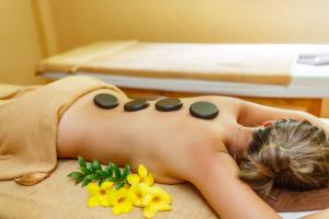 a woman laying on her back on a bed with flowers at Bauhinia Resort & Spa Phu Quoc in Phú Quốc