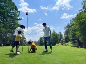 a group of people playing a game of golf at Kusatsu Onsen Hotel Village in Kusatsu
