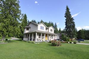 a white house with a large yard with grass at Cornerstone Bed and Breakfast in Revelstoke