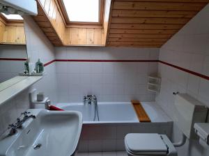 a bathroom with a tub and a toilet and a sink at Casa bianca in Malè