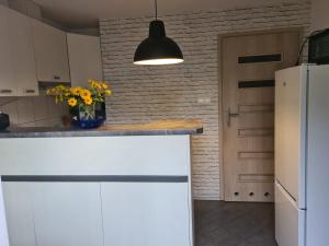 una cocina con un mostrador blanco con un jarrón de flores en Apartament Bema, en Biała Podlaska