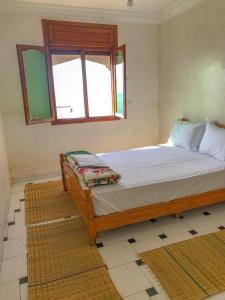 een slaapkamer met een bed en een raam bij Blue Beach Apartments in Taghazout