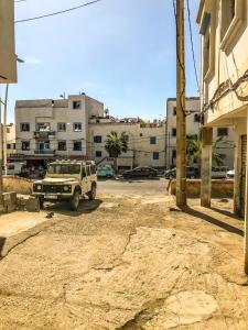 een jeep geparkeerd op een parkeerplaats naast een gebouw bij Blue Beach Apartments in Taghazout