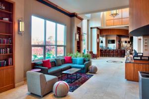 uma sala de estar com um sofá azul e almofadas vermelhas em Four Points by Sheraton Melville Long Island em Plainview
