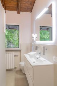 a bathroom with a sink and a toilet and a mirror at Amata Berghem Casa Vacanze con auto a disposizione in Aviatico