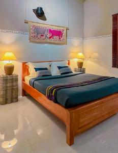 um quarto com uma cama grande e 2 candeeiros em Chang's Hideaway homestay ConDao em Con Dao