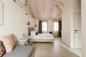 sypialnia z łóżkiem i kanapą w pokoju w obiekcie Limeria studios & maisonettes w mieście Parga