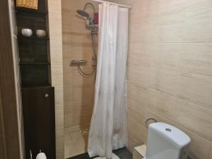 y baño con ducha con cortina blanca. en Apartament Bema, en Biała Podlaska