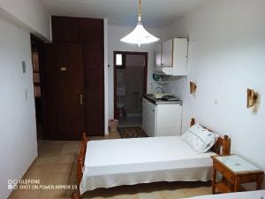 a small room with a bed and a kitchen at Matina's house in Samos