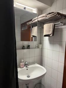 a bathroom with a sink and a mirror and towels at Apartment (2) am Stuttgarter Flughafen / Messe in Leinfelden-Echterdingen