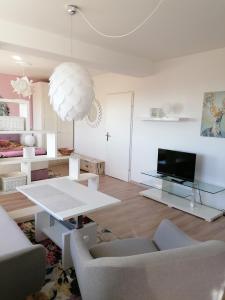un soggiorno con tavolo bianco e TV di Summer Wine a Leutschach