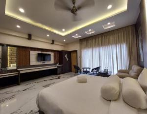 um quarto de hotel com uma cama grande e uma sala de estar em Grand Beach Resort em Mandarmoni