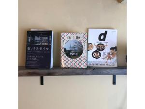 tres libros están sentados en un estante en Asahikawa Henshushitsu - Vacation STAY 13647, en Asahikawa