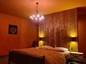 a bedroom with a bed and a chandelier at Hemelse Helderheid in Maasmechelen