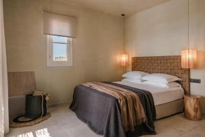 a bedroom with a large bed with a window at Uberina - Olea Di Assos Villas in Asos