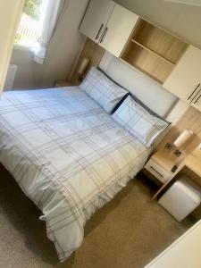 a bedroom with a bed with white sheets and pillows at Charming 2-Bed Chalet in Tuxford in Tuxford