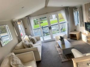 a living room with white furniture and a balcony at Charming 2-Bed Chalet in Tuxford in Tuxford