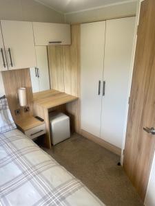 a small bedroom with a bed and a desk at Charming 2-Bed Chalet in Tuxford in Tuxford